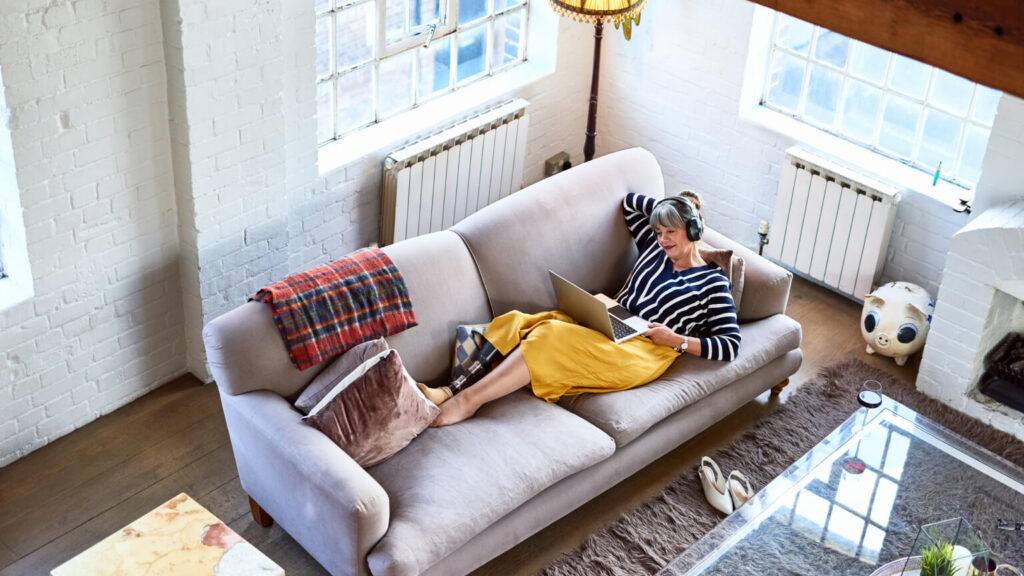 Woman with prosthetic leg watching movie on laptop, wearing headphones, leisure activity, relaxation, lifestyles